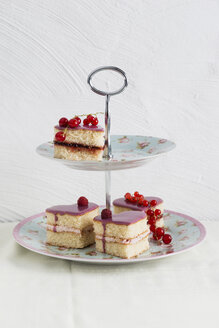 Small biscuit cakes in heart shape with raspberry cream and currant jelly, cake stand - MYF001075