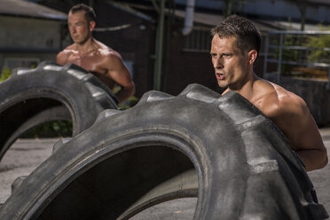 Zwei CrossFit-Sportler trainieren mit Traktorreifen - MADF000377