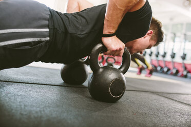 CrossFit-Sportler macht Liegestütze mit Kettlebells - MADF000396