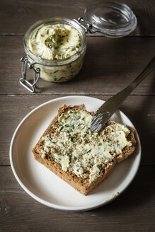 Kräuterbutter, Scheibe Dinkelbrot auf Teller - EVGF001898