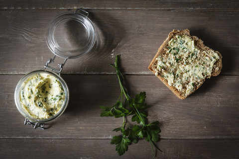 Kräuterbutter, Scheibe Dinkelbrot auf Holz, lizenzfreies Stockfoto