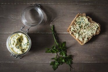 Kräuterbutter, Scheibe Dinkelbrot auf Holz - EVGF001899