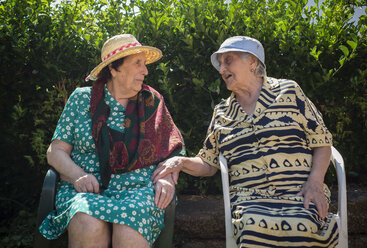 Zwei ältere Frauen unterhalten sich im Garten - RAEF000232