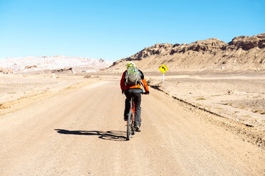 Chile, Man ridding a mountain bike throught the Valle de la Luna, Atacama Desert - GEMF000262