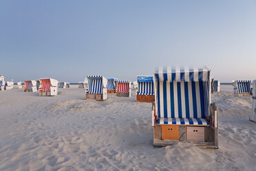 Germany, North Sea, wicker chairs on the beachfront in the evening - MEMF000824