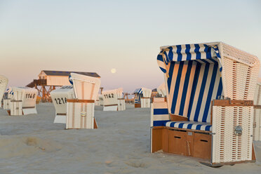 Germany, North Sea, wicker chairs on the beachfront in the evening - MEMF000825