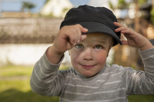 Porträt eines kleinen Jungen, der die Mütze eines Erwachsenen trägt - PAF001447
