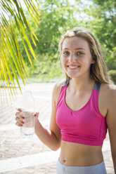 Mexico, Nayarit, portrait of smiling teenage girl holding water bottle - ABAF001826