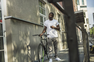 Porträt eines jungen Mannes mit Fahrrad - RIBF000115