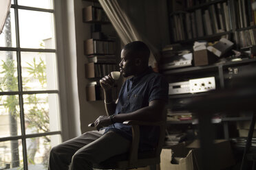 Young man drinking coffee in his studio - RIBF000149