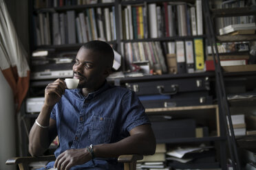 Young man drinking coffee in his studio - RIBF000150