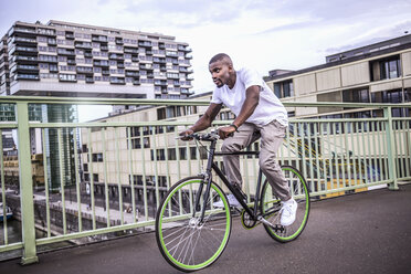 Deutschland, Köln, junger Mann fährt Fahrrad auf der Rheinbrücke - RIBF000138