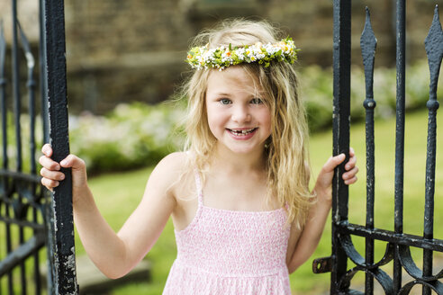 Portrait of smiling girl with tooth gap wearing floral wreath - GDF000764