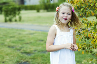 Porträt eines lächelnden Mädchens mit weißem Sommerkleid und Blumen - GDF000776