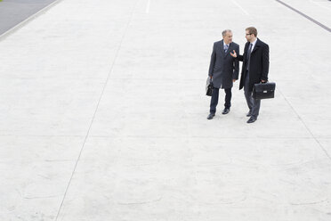 Two businessmen walking and talking outdoors - WESTF021335