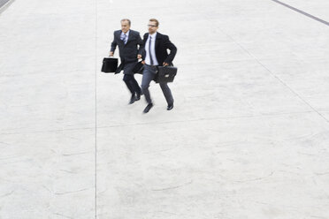 Two businessmen running outdoors - WESTF021336