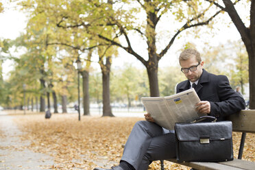 Geschäftsmann auf Parkbank beim Lesen einer Zeitung - WESTF021382