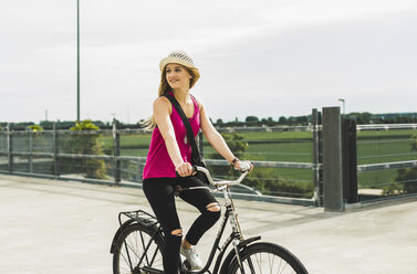 Teenager-Mädchen fährt Fahrrad auf einem Parkdeck - UUF004858