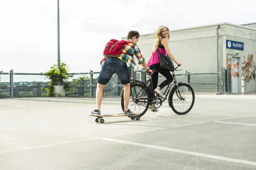 Happy young couple with bicycle and skateboard - UUF004861