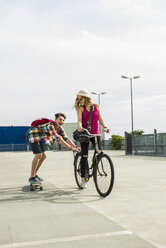 Happy young couple with bicycle and skateboard - UUF004862