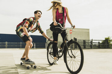 Happy young couple with bicycle and skateboard - UUF004866