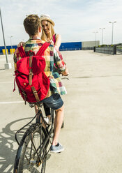 Glückliches junges Paar zusammen auf einem Fahrrad - UUF004876