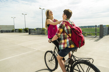 Glückliches junges Paar zusammen auf einem Fahrrad - UUF004878