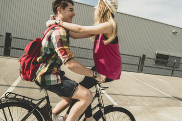 Glückliches junges Paar zusammen auf einem Fahrrad - UUF004880