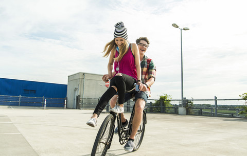 Happy young couple together on a bicycle stock photo