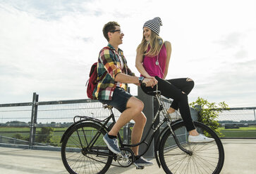 Happy young couple together on a bicycle - UUF004883