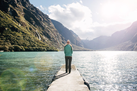 Peru, Frau steht auf einem Steg und schaut auf die Lagune Llanganuco, lizenzfreies Stockfoto