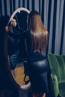 Rückenansicht einer jungen Frau, die in einen Spiegel schaut - CHAF000536