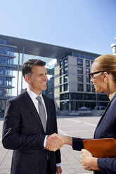 Germany, Stuttgart, businessman and businesswoman shaking hands - CHAF000357