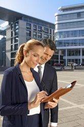 Germany, Stuttgart, two business people reading a document - CHAF000352