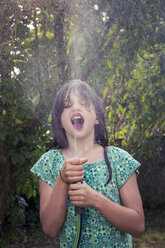 Girl cooling herself with garden hose - LVF003681