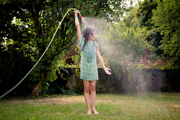 Girl cooling herself with garden hose - LVF003675