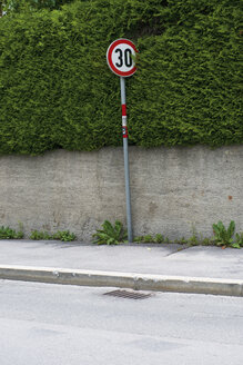 Straßenschild neben einer Hecke auf dem Bürgersteig - VIF000328