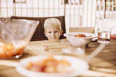 Porträt eines lächelnden kleinen Jungen, der auf einem Balkon sitzt - MFF001812
