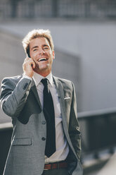 Smiling businessman talking on cell phone outdoors - CHAF000554