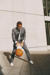 Businessman playing basketball outdoors - CHAF000437