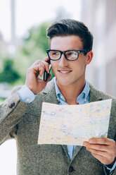 Young man on the phone holding map - CHAF000557