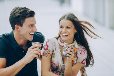 Glückliches junges Paar trinkt Kaffee im Freien - CHAF000448