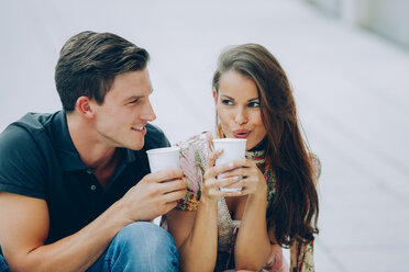 Lächelndes junges Paar beim Kaffeetrinken im Freien - CHAF000449