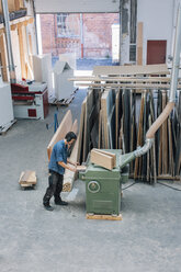 Carpenter working with planing machine in workshop - JUBF000021