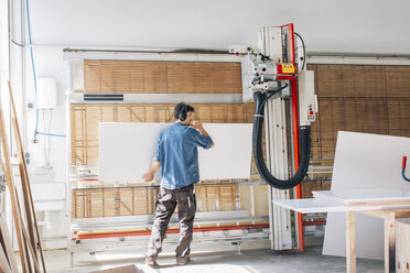 Schreiner schneidet Holz in der Werkstatt mit Maschine - JUBF000045
