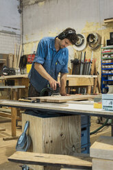 Carpenter using grinding machine in workshop - JUBF000025