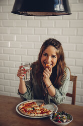 Junge Frau isst Pizza im Restaurant - CHAF001295