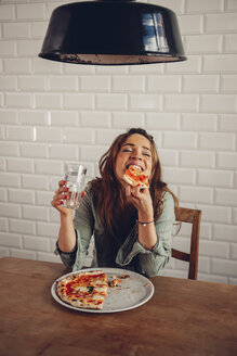 Young woman eating pizza in restaurant - CHAF001296