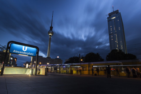 Deutschland, Berlin, beleuchteter U-Bahnhof und Straßenbahn vor dem Fernsehturm am Alexanderplatz, lizenzfreies Stockfoto