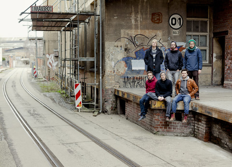 Gruppenbild von sechs Freunden auf dem Bahnsteig, lizenzfreies Stockfoto